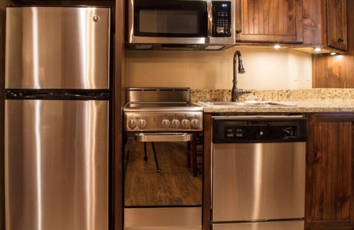 Gatlinburg Villa | Spacious 3-bedroom cabin — 2,746 sq ft, sleeps up to 12 — full kitchen, in-unit washer/dryer and multiple living areas with balcony mountain views. Enjoy on-site Wild Bear Falls indoor water park, heated pools, award-winning spa, and dining.